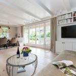 Living and dining area with TV, bookshelf, and garden view