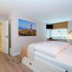 Bedroom with bed, wall art, and desk