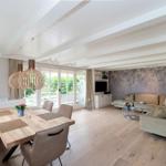 Large living and dining area with wooden floor and dining space.