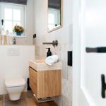 Bathroom with sink, toilet, and window with flowers.