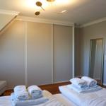 Schlafzimmer mit Bett, Kleiderschrank und Spiegel.