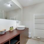 Badezimmer mit Waschbecken, Spiegel und Heizkörper