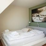 Schlafzimmer mit Bett, Wandbild und Lampe