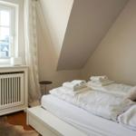 Schlafzimmer mit Dachschräge, Fenster und Bett mit Handtüchern.