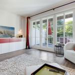 Wohnzimmer mit Fernseher, Sofa und Blick auf Terrasse