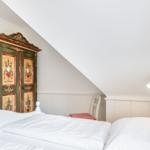 Schlafzimmer mit Bett, Kleiderschrank und Nachttisch.
