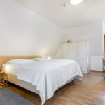 Bedroom with double bed, wardrobe, and desk.