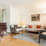 Living room with sofa, armchairs, and wooden floor