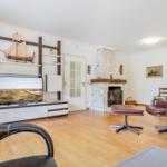 Living room with fireplace, TV, and brown leather armchair.
