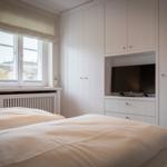Bedroom with double bed, window, and built-in TV.