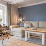 Living room with sofa, coffee table, and chair by large window.