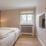 Bedroom with double bed, window, and built-in TV area.
