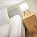 Schlafzimmer mit Bett, Nachttisch und Lampe.