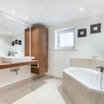 Badezimmer mit Badewanne, Waschbecken und Spiegel