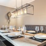 Esszimmer mit Holztisch, grauen Stühlen und moderner Deckenleuchte.