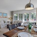 Dining area with table and chairs, view of living area with sofa and fireplace.