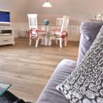 Wohnzimmer mit Sofa, Fernseher und Essbereich mit Tisch und Stühlen.