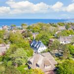 Village with thatched roofs and view of the sea.