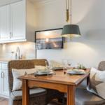Esszimmer mit Tisch, Stühlen und Küchenzeile