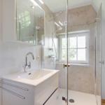 Badezimmer mit Dusche, Waschbecken und Fenster
