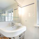 Bathroom with sink, mirror, and window.
