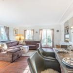 Living and dining area with sofa, table, and windows.