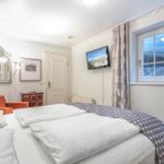 Bedroom with double bed, window with sea view, and wall-mounted TV.