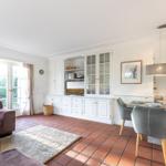 Living and dining area with dining table, sofa, TV, and terrace door.
