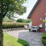 Red brick house with stone path and garden furniture.