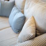 A sofa with striped upholstery and blue cushions.