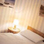 Bedroom with bed, nightstand, and lamp against striped wall