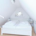 Ein Schlafzimmer mit Doppelbett, weißen Wänden und einem Kissenständer.