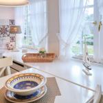 Küche mit weißem Tisch, blauer Schüssel und Blick auf Garten