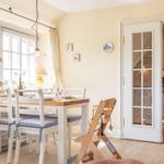 Dining room with table, chairs, and view into the kitchen.