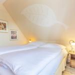 Bedroom with double bed, nightstand, and wall mural