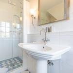 Bathroom with shower, sink, and mirror.