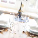 Table with dishes and glasses near window