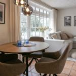 Essbereich mit runder Tisch und Stühlen, Wohnbereich mit Sofa und Fenster.