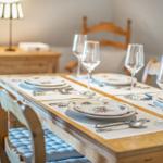 Holztisch mit Platzdeckchen und Geschirr für vier Personen.