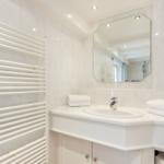Badezimmer mit Waschbecken, Spiegel und Heizkörper