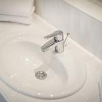 Waschbecken mit Chromhahn auf weißem Waschtisch