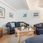 Wohnzimmer mit zwei Sofas, Holztisch und Wandbildern.
