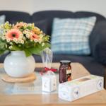Auf dem Tisch steht eine Blumenvase, ein Glas und Verpackungen.