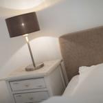 Schlafzimmer mit Nachttisch und Lampe neben dem Bett
