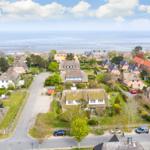 Dorf mit strohgedeckten Häusern und Blick auf die Nordsee.