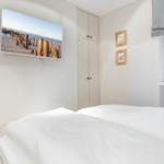 Schlafzimmer mit Bett, TV und Kleiderschrank