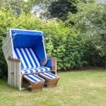 Blau-weiße Strandliege mit Schirm im Garten