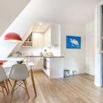 Küche mit Esstisch, roter Lampe und Glaswand mit Seepferdchenmotiv.