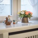 Three duck figurines and a flower vase are on the windowsill.