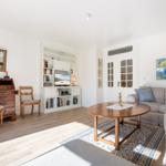 Living room with sofa, wooden table, bookcase, and TV.